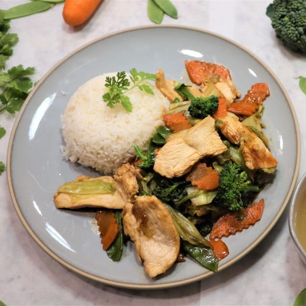 BaoBao Kitchen's chicken stir-fry with broccoli, carrots, and snow peas, served with white rice.